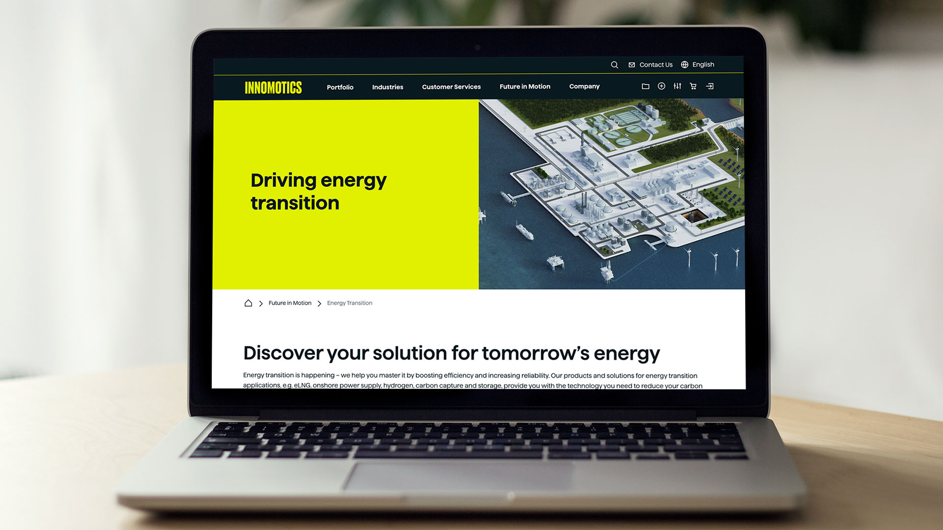 Laptop zeigt die Innomotics-Webseite mit dem Titel ‚Driving energy transition‘ und einer Visualisierung eines Industrieareals.